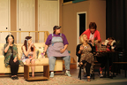 A woman wearing a green vest, a woman with a headband, a woman with an apron and baseball cap, a woman in a leopard print outfit, a
       woman wearing a red robe and a woman who thinks she's a cat