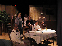 Three women and three men standing or sitting at a table